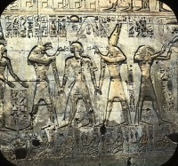 Боги Упуаут и Гор держат за руки фараона. За Гором стоит бог Тот